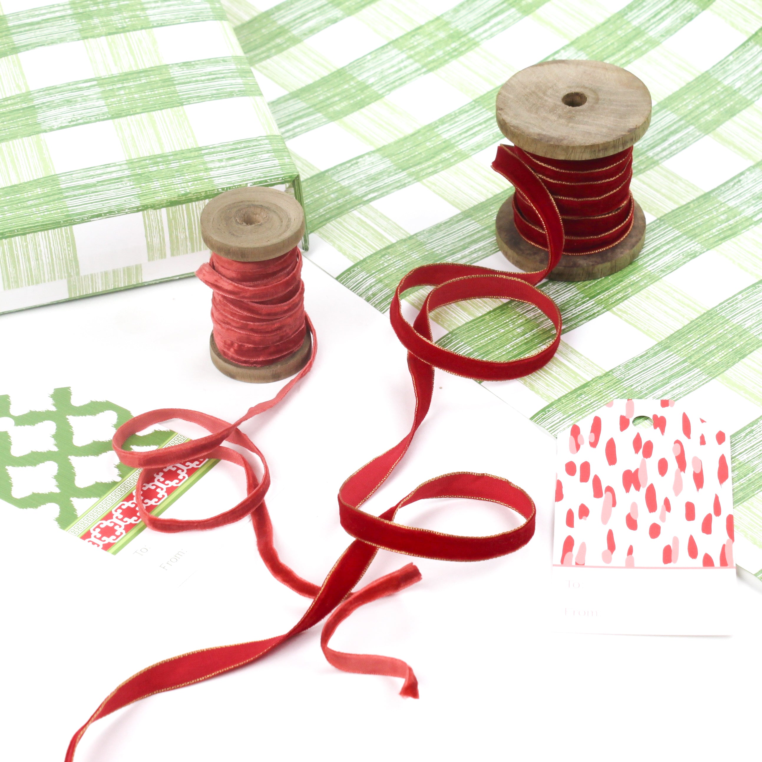 Green gingham wrapping paper sheet shown with red and pink velvet ribbons.