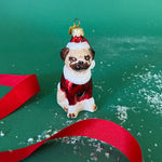 Pug dog ornament in a red outfit with a green background