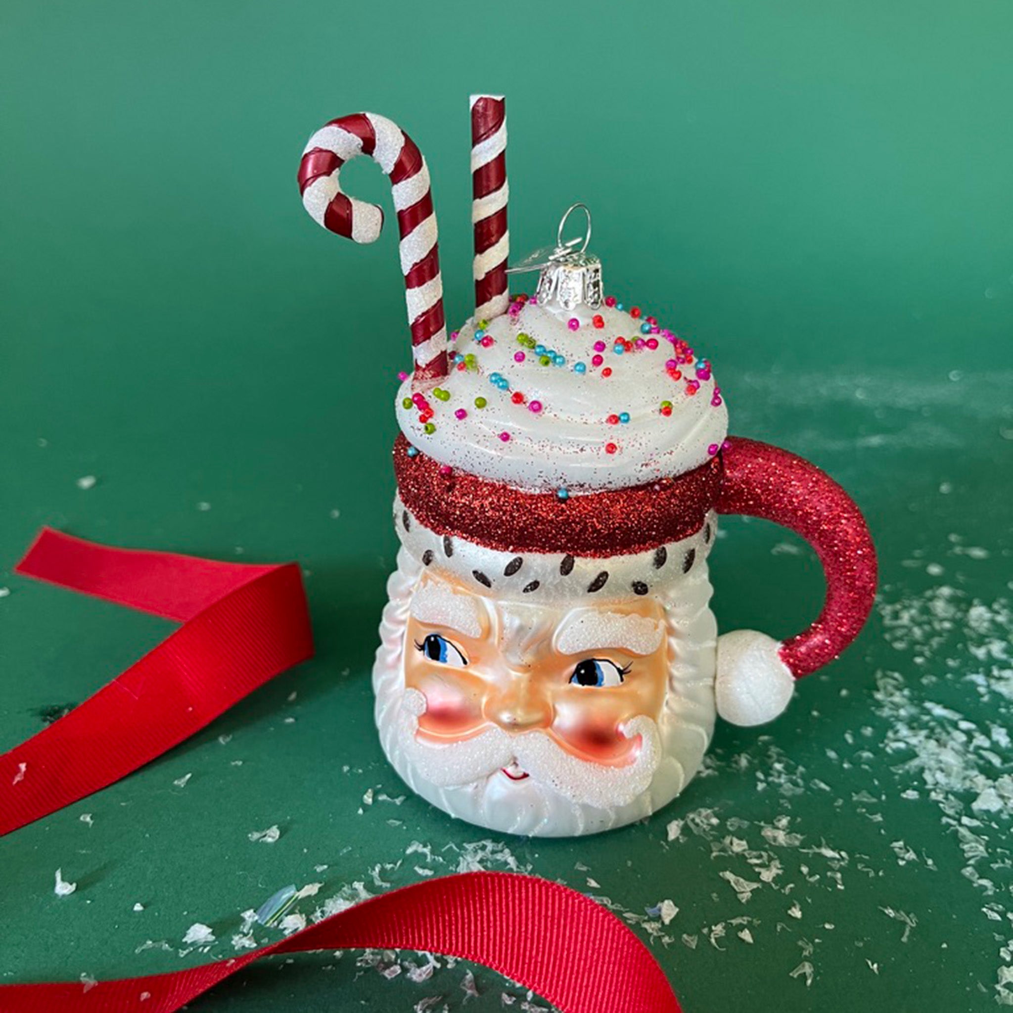 Glass Santa Mug with Glitter Candy Cane Christmas Ornament in a green background