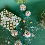 six silver disco ball christmas ornaments on a green background