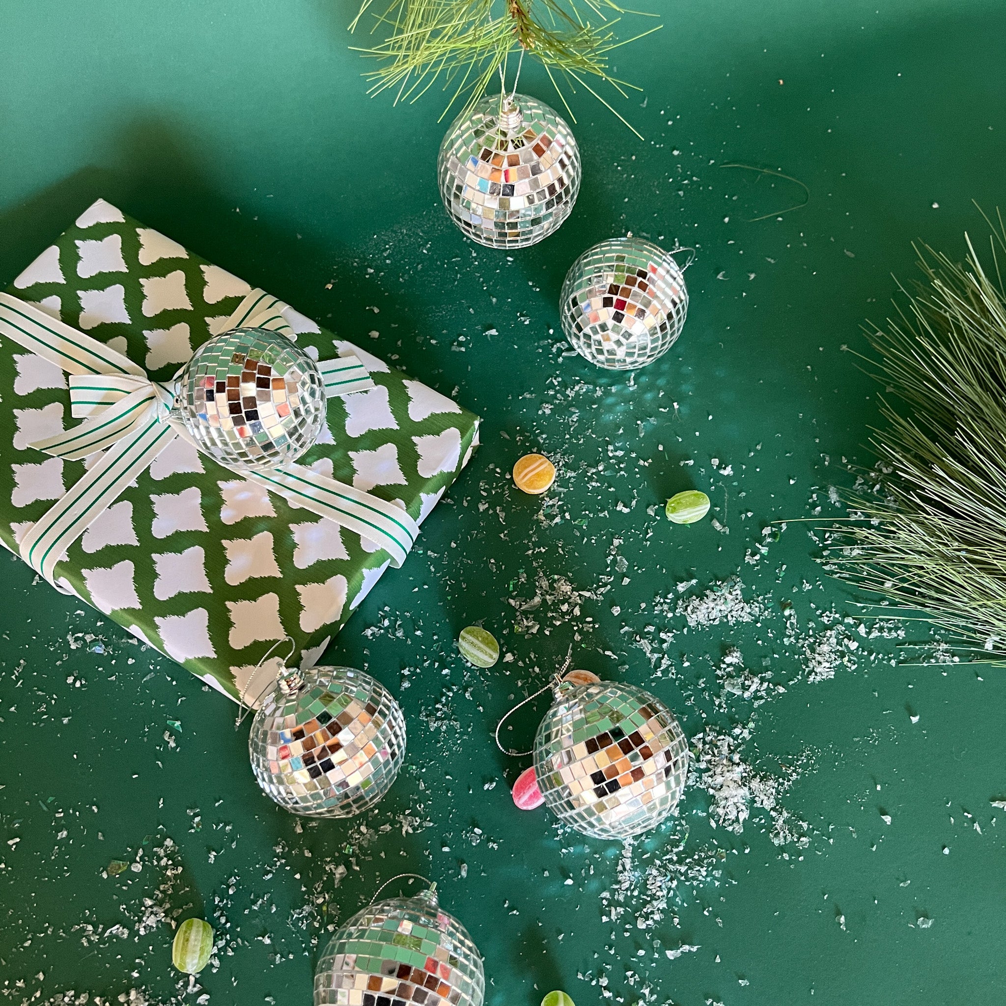 six silver disco ball christmas ornaments on a green background