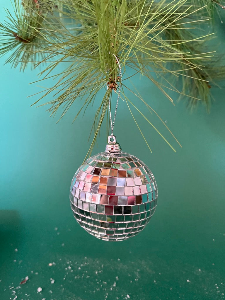 mini silver disco ball christmas ornaments on a green background