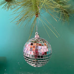 mini silver disco ball christmas ornaments on a green background