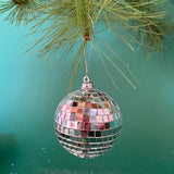 mini silver disco ball christmas ornaments on a green background