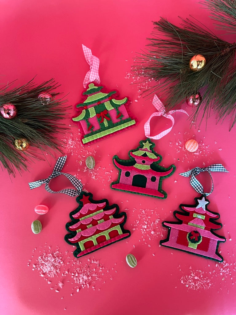 four pink felt chinoiserie christmas ornaments in the shape of pagodas against a white background 