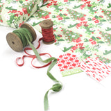 Styled display of Pug gift wrapping paper with green and red ribbons and gift tags.