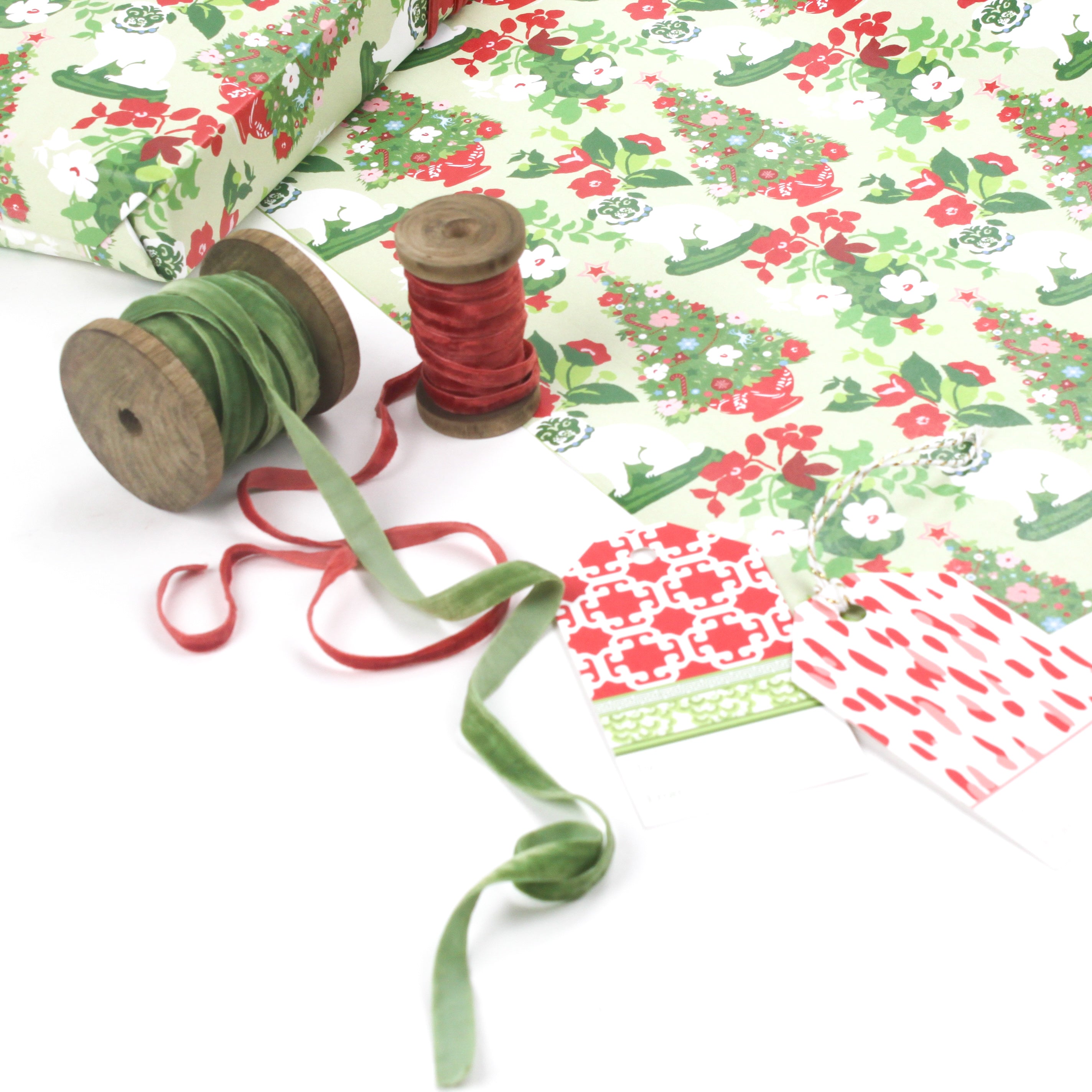 Styled display of Pug gift wrapping paper with green and red ribbons and gift tags.