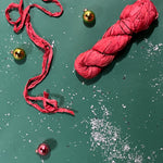 a recycled torn-silk ribbon in pink laid in a green surface