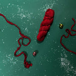 a recycled torn-silk ribbon in red laid in a green surface