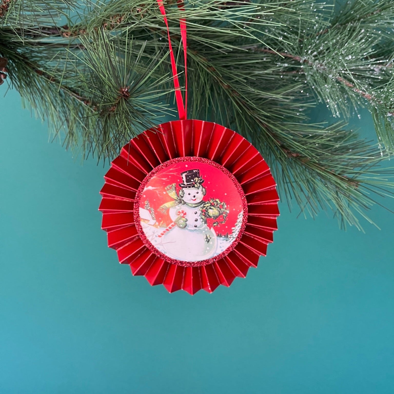 retro-style ruffled paper Christmas ornaments featuring vintage illustration, accented with red pleated borders and hanging ribbons