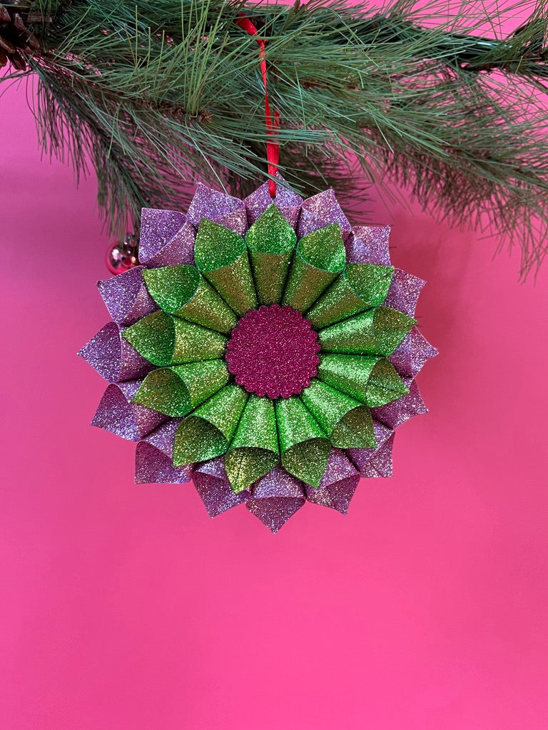 ruffled paper Christmas ornaments in shimmering green and purple glitter with red centers