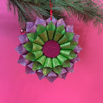 ruffled paper Christmas ornaments in shimmering green and purple glitter with red centers