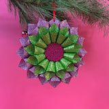 ruffled paper Christmas ornaments in shimmering green and purple glitter with red centers