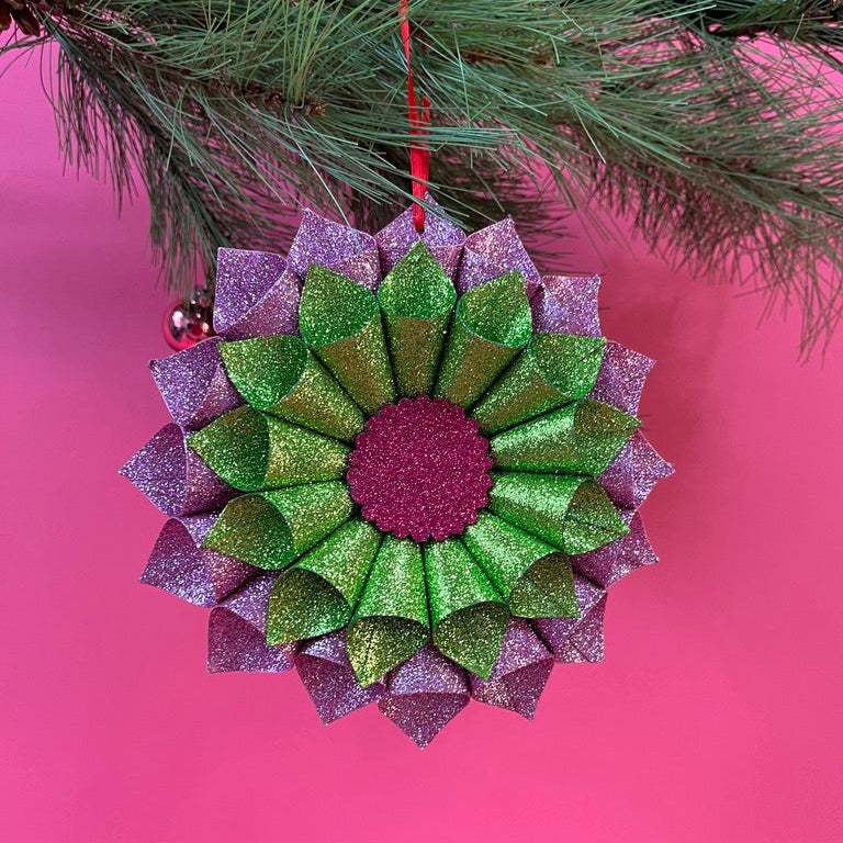 ruffled paper Christmas ornaments in shimmering green and purple glitter with red centers