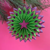 ruffled paper Christmas ornaments in shimmering green and purple glitter with red centers