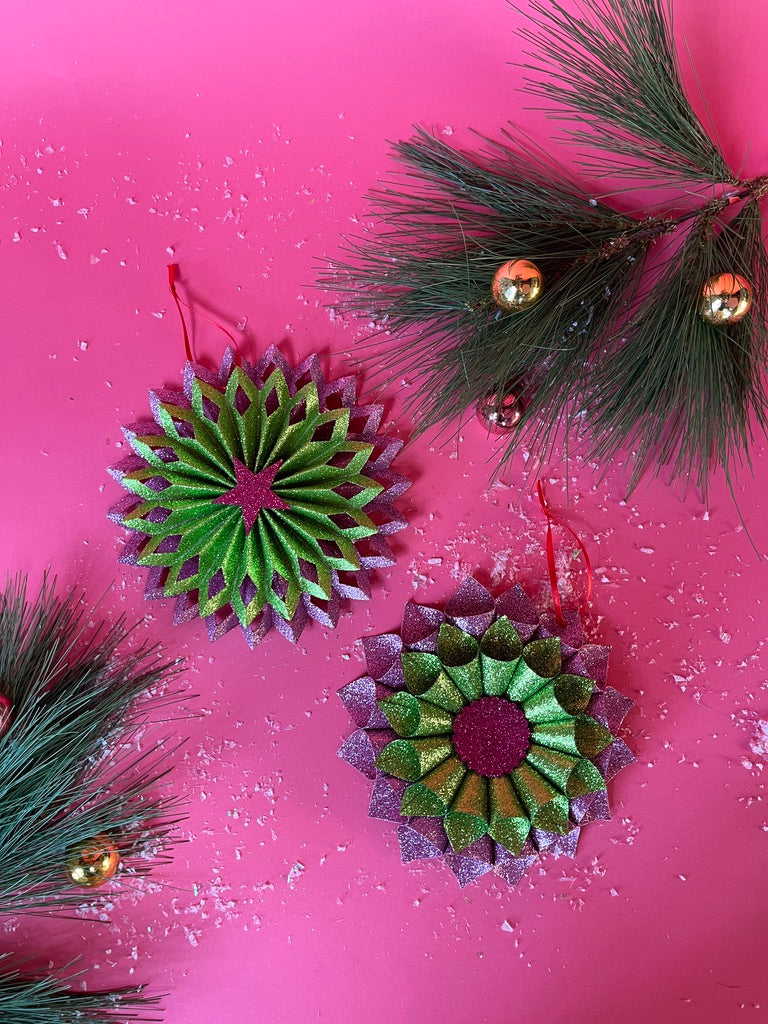 ruffled paper Christmas ornaments in shimmering green and purple glitter with red centers