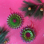 ruffled paper Christmas ornaments in shimmering green and purple glitter with red centers