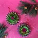 ruffled paper Christmas ornaments in shimmering green and purple glitter with red centers