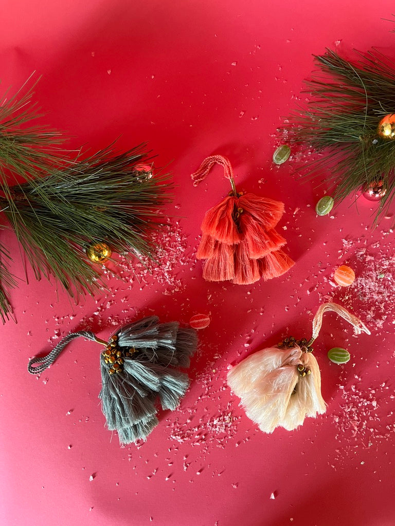elegant tassel Christmas ornaments with small gold bells on a red background