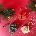 elegant tassel Christmas ornaments with small gold bells on a red background