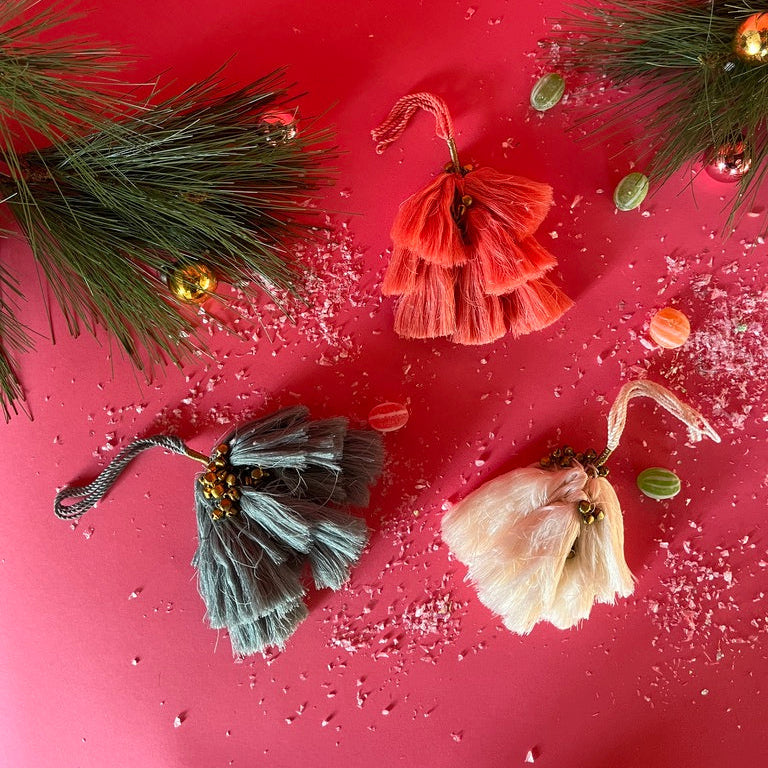 elegant tassel Christmas ornaments with small gold bells on a red background
