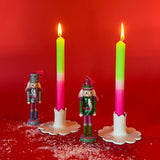 lighted 2 Bright Pink Green Taper Candles in a holder with red background