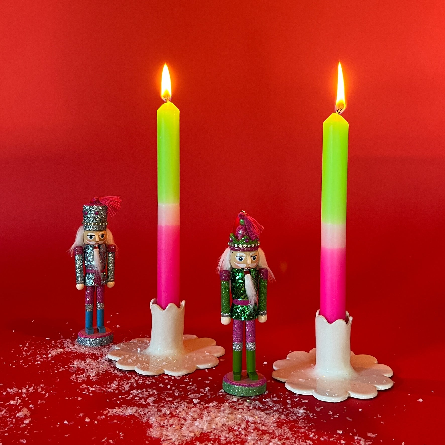 lighted 2 Bright Pink Green Taper Candles in a holder with red background