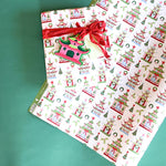 Gift wrapped in pagoda Christmas print paper with red ribbon and matching holiday tag.