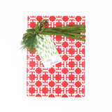 A green gift tag with a geometric pattern, attached to a wrapped present