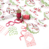 Styled display of mouse-themed holiday wrapping paper with pink ribbons and assorted gift tags.