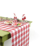 a green table covered by a Gin Lane Red Gingham Paper Table Runner on a white background
