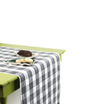 a green table covered with a black paper table runner in a black and white gingham pattern from madcap cottage