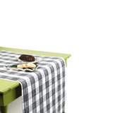 a green table covered with a black paper table runner in a black and white gingham pattern from madcap cottage