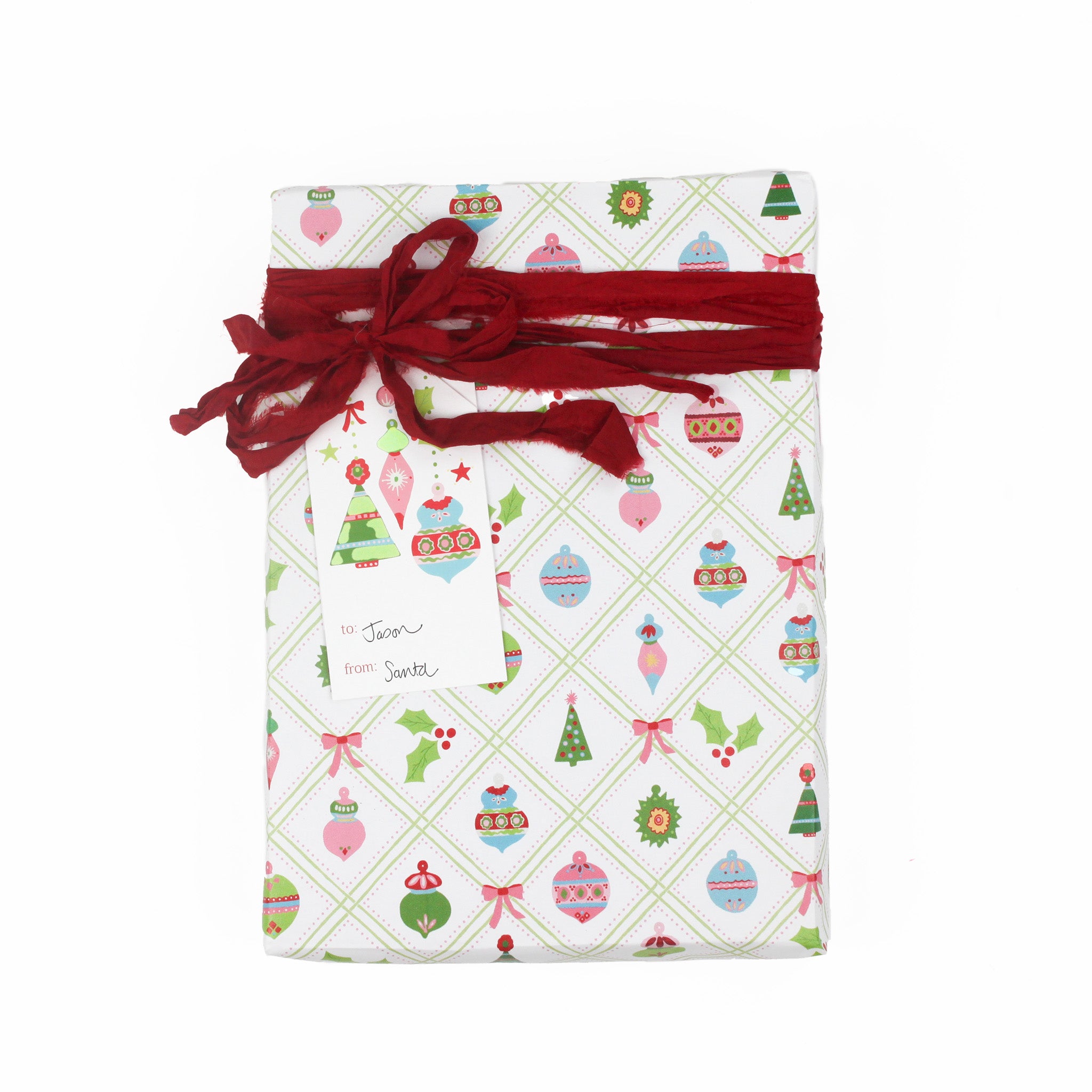 A pink Christmas ornaments gift tag with a space for personalize message, attached to a wrapped present