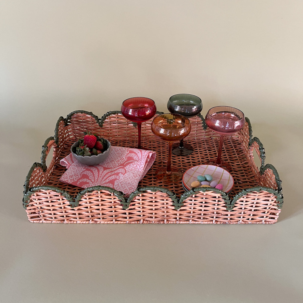 green rattan serving tray styled with champagne glasses, side view
