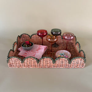 green rattan serving tray styled with champagne glasses, side view