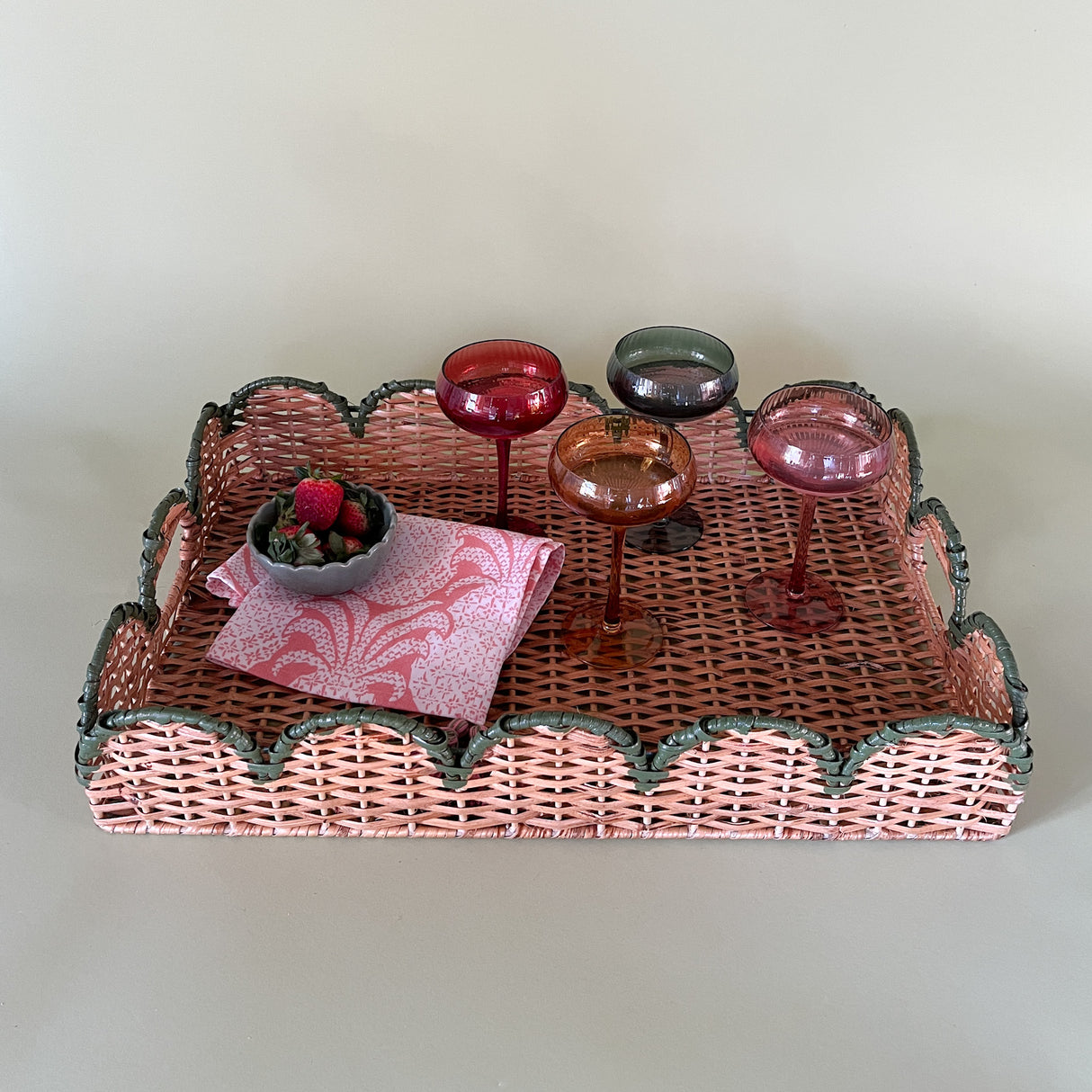 green rattan serving tray styled with champagne glasses