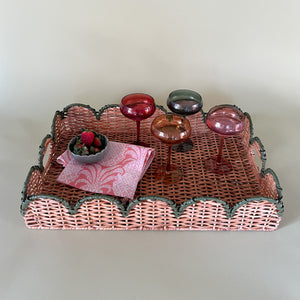 green rattan serving tray styled with champagne glasses