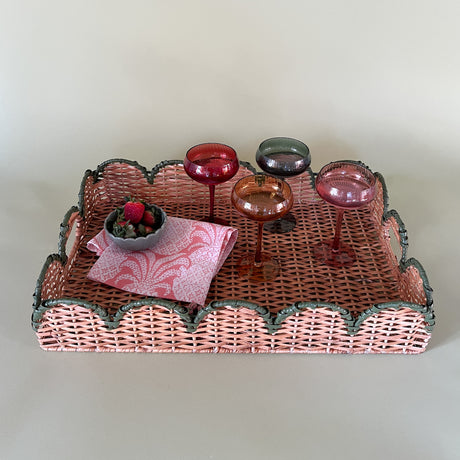 green rattan serving tray styled with champagne glasses