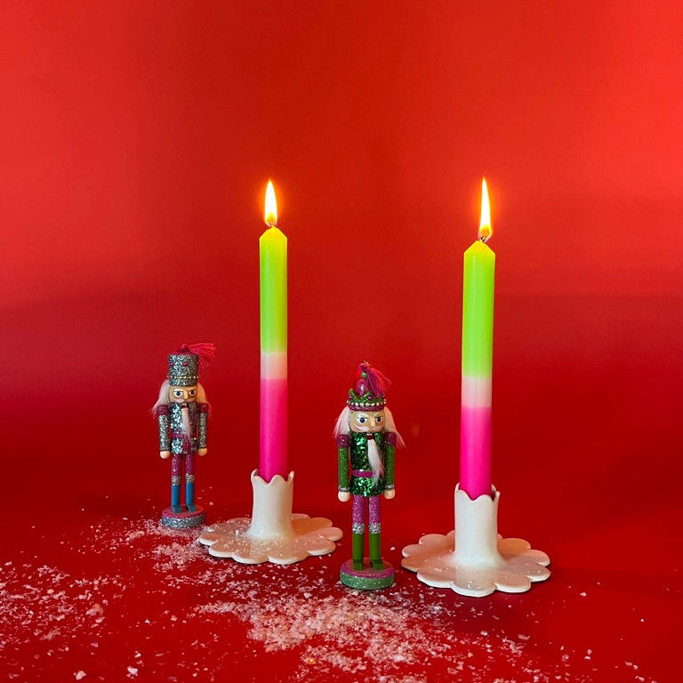lighted 2 Light Pink Green Taper Candles in a holder with red background