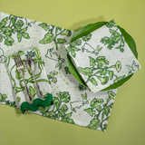 a springtime strawberry print fabric easter table runners in green with a plate, napkin and cutlery