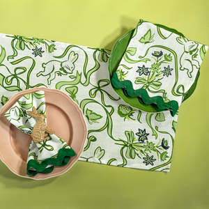 a green and white  table runner and napkin in a  bunny and bow print fabric. 