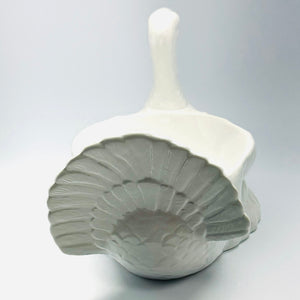 the tail of a white ceramic turkey centerpiece
