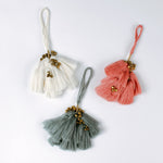 Set of three elegant tassel Christmas ornaments in white, coral and blue with small gold bells