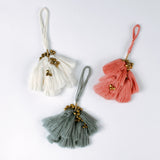 Set of three elegant tassel Christmas ornaments in white, coral and blue with small gold bells