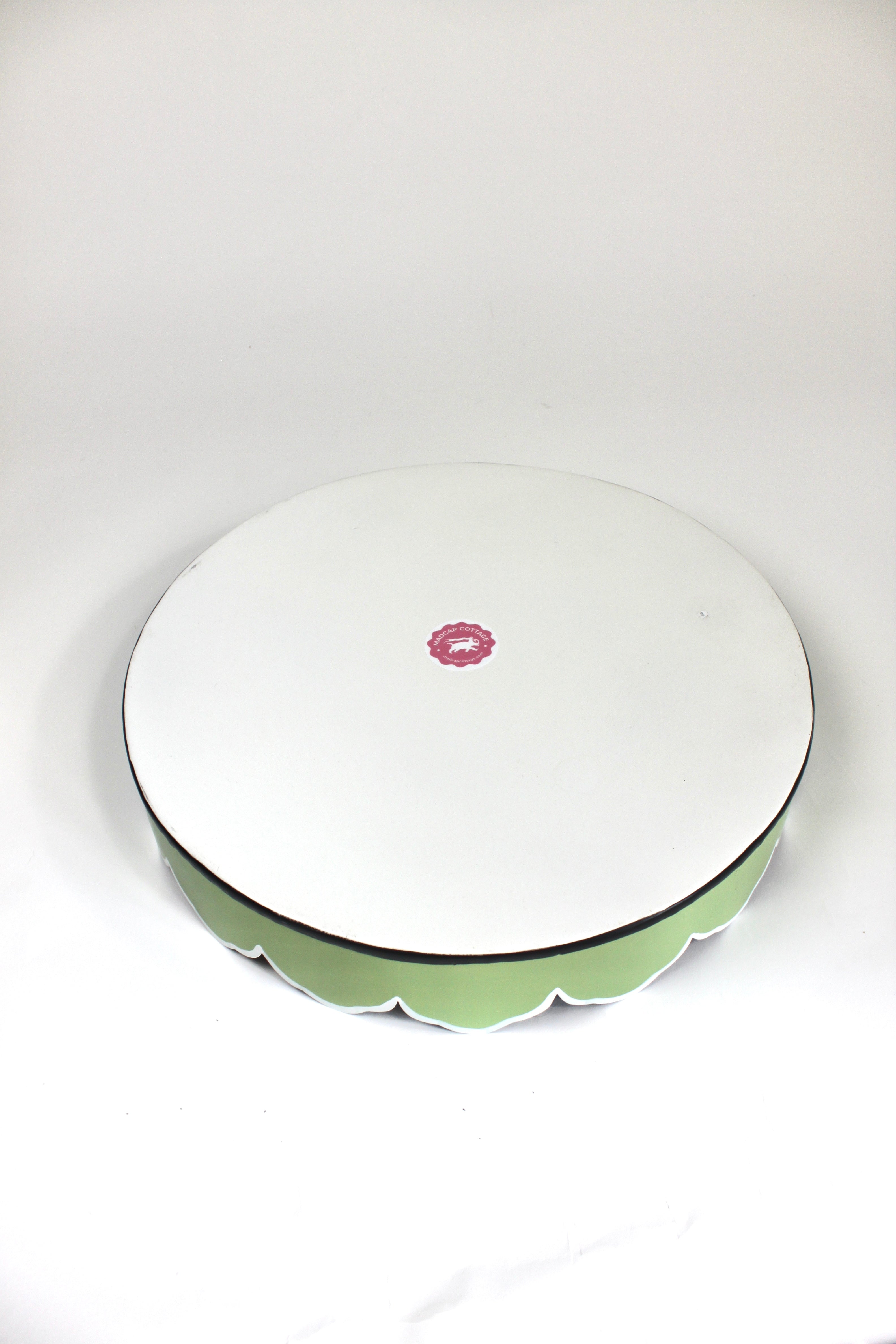 The plain white reverse side of Temple Garden, a tole metal tray with scalloped edges in green with a pink and green chinoiserie peony blossom pattern