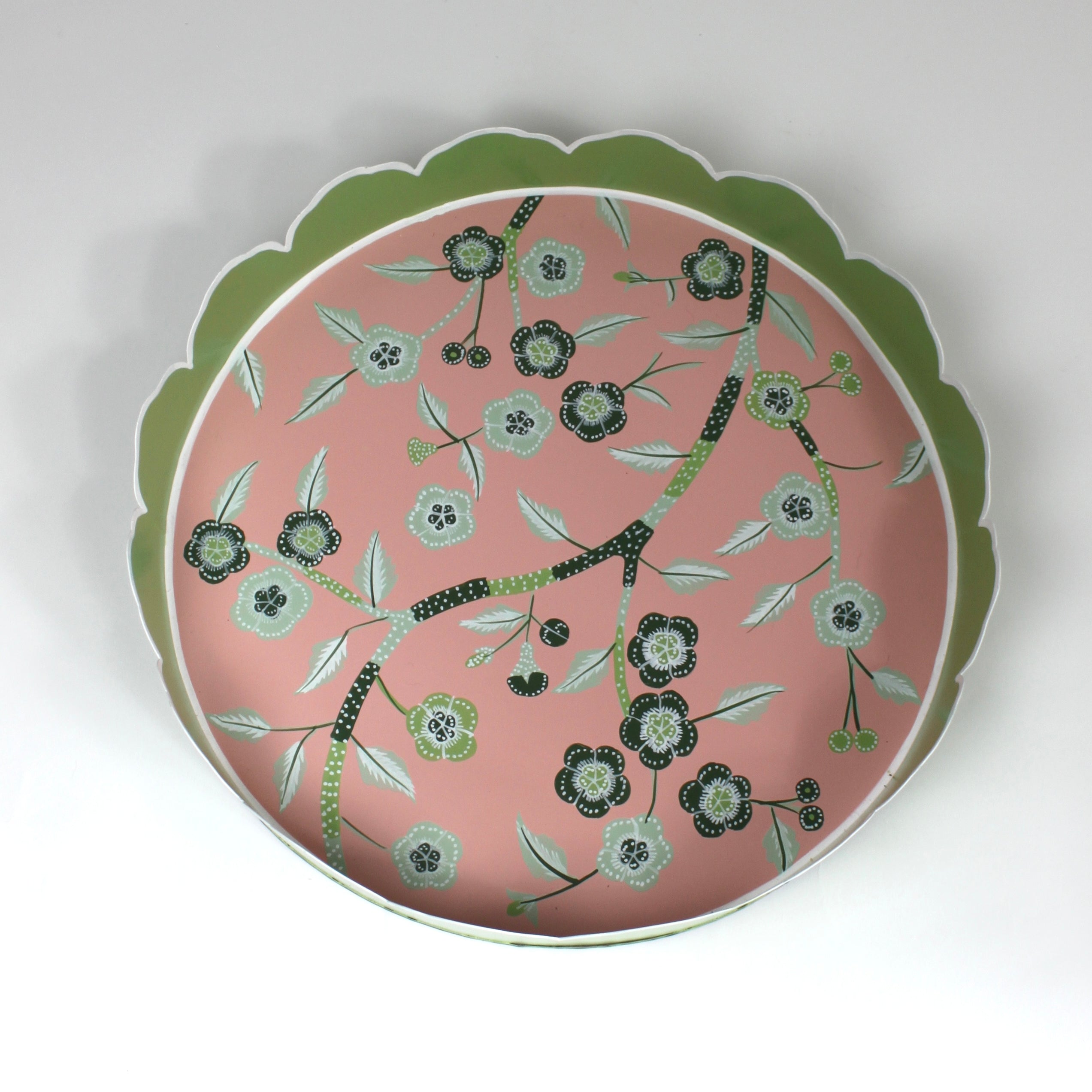 An aerial view of Temple Garden, a tole metal tray with scalloped edges in green with a pink and green chinoiserie peony blossom pattern