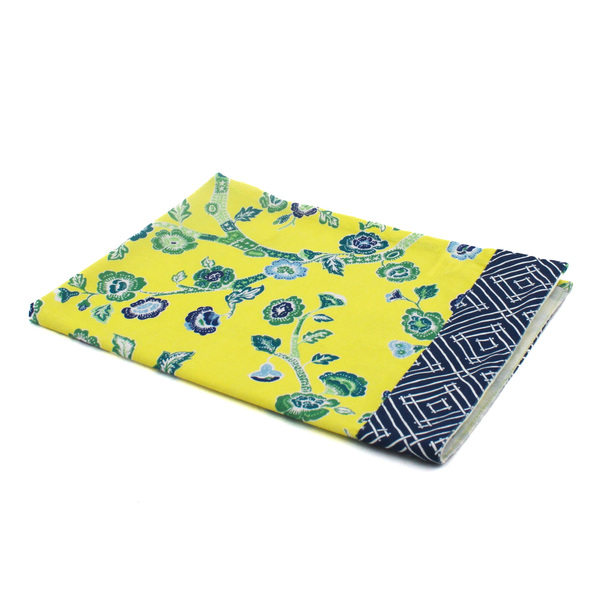 A yellow chinoiserie tea towel with a blue cherry blossom motif and a blue lattice pattern border against a white background. 