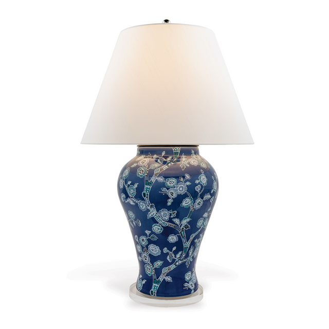 A blue and white table lamp featuring a blue and white chinoiserie lamp base and a white lampshade. 