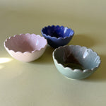 three scalloped bowls in white, blue and green